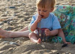 ребенок ест песок